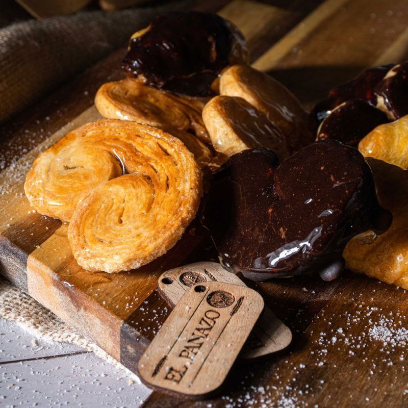 Sumérgete en la frescura crujiente de nuestra bollería artesanal. Las palmeras de chocolate seducen con capas delicadas, mientras que los bollos clásicos despiertan nostalgia. Cada mordisco es un viaje sensorial, donde la calidad y la tradición se fusionan en cada hojaldre.