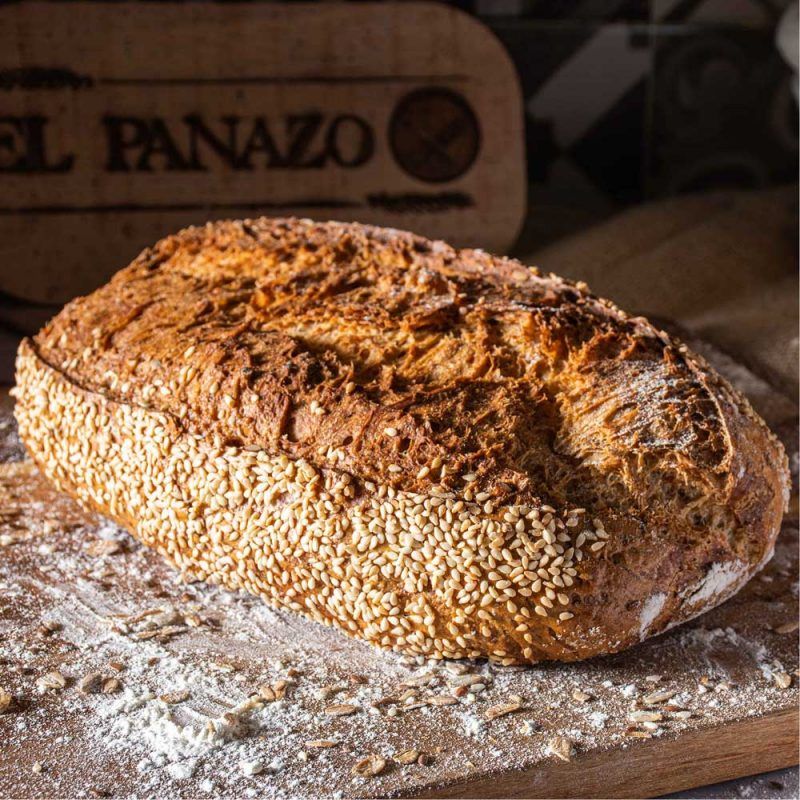 Pan artesanal recién horneado, con una costra dorada y crujiente que encierra la esencia de la tradición. Disfruta el deleite de cada rebanada, donde la maestría y la calidad se unen. Descubre el auténtico sabor del pan hecho a mano en cada detalle